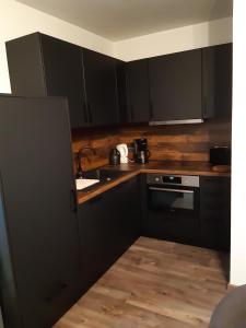 a kitchen with black cabinets and a sink at Ferienwohnung Mörchen in Winterberg