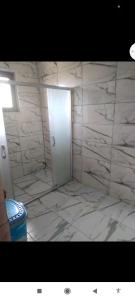 een badkamer met een witte marmeren vloer en een deur bij Demirtepe Konuk Evi in Gelibolu