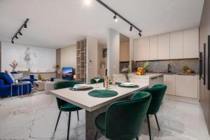 een keuken en eetkamer met een tafel en groene stoelen bij Abau Residence Apartment 2 Opatija in Opatija