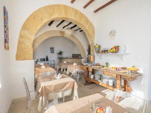 a dining room with tables and a large archway at Tannur B&B in Castellammare del Golfo