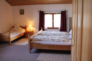 1 dormitorio con 2 camas y ventana en Widernhof, en Prien am Chiemsee