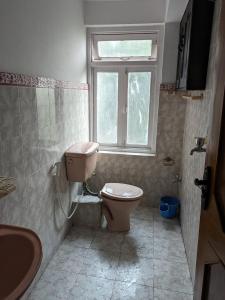 La salle de bains est pourvue de toilettes et d'une fenêtre. dans l'établissement Budget Backpacker's Hostel, à Pātan