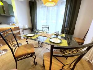 a dining room table with chairs and a glass table at Appart Cosy tt confort - Sceaux - 20mn de Paris in Sceaux
