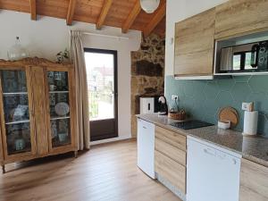 a kitchen with wooden cabinets and a counter top at A Solaina da Bouza in Cambados