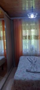 een slaapkamer met een bed en een kroonluchter bij Niku HomeStay in Berat
