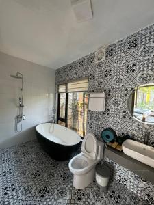 La salle de bains est pourvue d'une baignoire, de toilettes et d'un lavabo. dans l'établissement Azalea Tam Coc Ninh Bình, à Ninh Binh