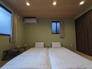 a bedroom with two beds and a window at Private Villa Tofukuji in Kyoto
