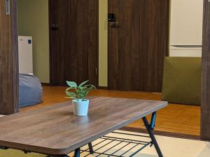 a potted plant sitting on a wooden table in a room at Private Villa Tofukuji in Kyoto