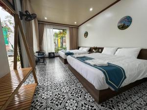 a bedroom with two beds and a balcony at Azalea Tam Coc Ninh Bình in Ninh Binh