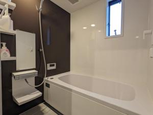 a white bathroom with a tub and a window at Private Villa Tofukuji in Kyoto +18 photos