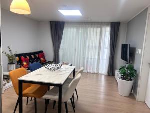 a dining table and chairs in a living room at Walking gate camp Humphreys in Pyeongtaek