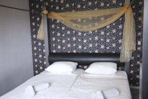 a bedroom with two beds with white sheets and a curtain at Villa Casa Jasmin in Melîyech