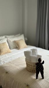 um ursinho de peluche numa cama com uma cesta de toalhas em House near the beach em Praia de Nai Yang