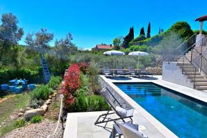 - une piscine dans un jardin avec des chaises et des fleurs dans l'établissement Vacation house Rubi, à Dubrovnik
