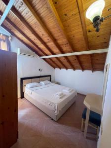 1 dormitorio con cama y techo de madera en unlu hotel, en Fethiye