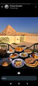a table topped with plates of food on top of a desert at Solima pyramids in Cairo