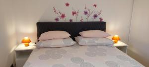 a bed with two pillows on it with two lamps at Adriana Apartment in Mali Lošinj