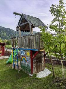 een houten speelplaats met een dak bij Apartment Wigo in Feldkirchen in Kärnten
