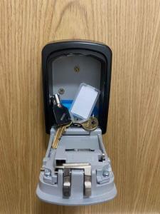 a suitcase with a cell phone and keys in it at North Kelvin Guest House in Glasgow