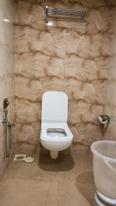 um WC branco numa casa de banho com uma parede de pedra em Golden View Dormitory em Mumbai