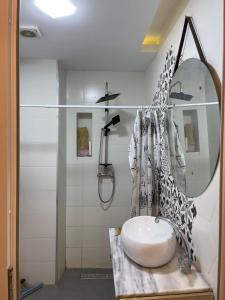 een badkamer met een wastafel, een douche en een spiegel bij Marina loft in Camp Inférieur