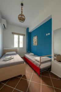 two beds in a room with a blue wall at Memories Gytheio in Gythio