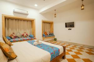 um quarto com 2 camas e uma televisão de ecrã plano em Explore Hostel Life Jaisalmer em Jaisalmer