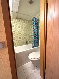 a bathroom with a toilet and a shower curtain at Kimbab Restaurant und Pension in Ruhla