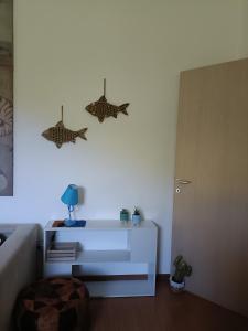 een woonkamer met twee vissen aan de muur bij A CASA di LELE CAPALBIO in Capalbio
