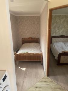 a small bedroom with a bed and a mirror at GuestHouse in Gyumri
