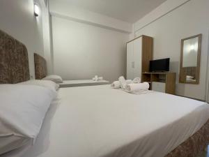 a large white bed in a room with a tv at Villa Deart Berat in Berat