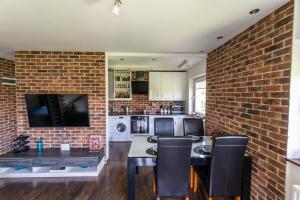 a kitchen with a brick wall and a table and chairs at LARGE LUXURY APARTMENT WIELICZKA in Wieliczka