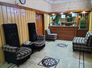 Karachi Motel Guest House في كراتشي: غرفة انتظار مع ثلاثة كراسي وبار