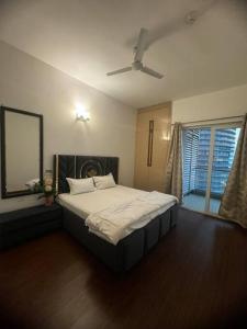 1 dormitorio con 1 cama grande y ventilador de techo en SkyHigh Serenity. 2 Bhk Apartment. 0 Km From Delhi, en Noida