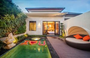 a backyard with a swimming pool and a house at Gaing Mas Jimbaran Villas by Gaing Mas Group in Jimbaran