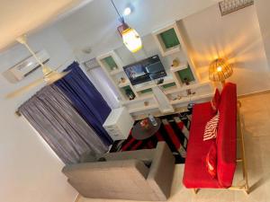 einen Blick über ein Wohnzimmer mit einem roten Sofa in der Unterkunft Plage Ewell in Cotonou