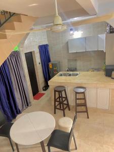 eine Küche mit einem Tisch, Stühlen und einer Theke in der Unterkunft Plage Ewell in Cotonou