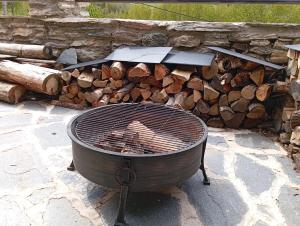 a grill sitting in front of a pile of logs at Espectacular Chalet de Montaña Pirineos, Burg in Burg