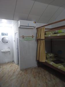 ein kleines Zimmer mit einem Etagenbett und einem Waschbecken in der Unterkunft Mukda in Ko Yao Noi