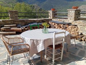 a table with chairs and a vase of flowers on a patio at Espectacular Chalet de Montaña Pirineos, Burg in Burg