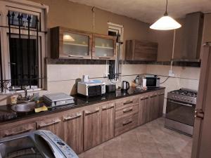 a kitchen with wooden cabinets and a counter top at Cozy Duplex Bungalow Near Seaside in Troux aux Biches in Trou aux Biches +7 photos