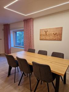 Villa Kataja في Siuntio: قاعة اجتماعات مع طاولة وكراسي خشبية