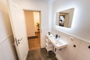 La salle de bains blanche est pourvue d'un lavabo et d'un miroir. dans l'établissement Schlachteperle, 2,5 Zimmer Wohnung in Bremen, à Brême