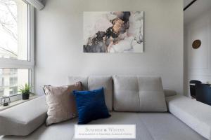 a living room with a couch with a blue pillow at Unique Luxury Butterfly & Bike Apartments, Gdynia Orłowo, 15 w pełni wyposażonych mieszkań, z dodatkową sypialnią, windą i płatnym parkingiem, wysoki standard SummerWinter in Gdynia
