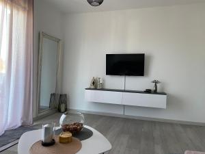 sala de estar con TV en una pared blanca en Apartment Lucia en Punat