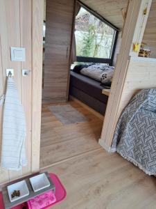 uma pequena casa com uma cama e uma janela em Sauerland Tinyworld em Diemelsee