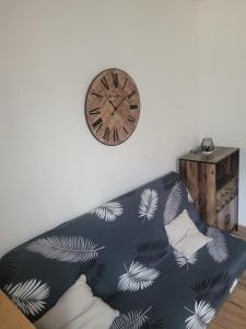 un divano con un orologio sul muro e un orologio di Studio en plein cœur d’aubusson ad Aubusson