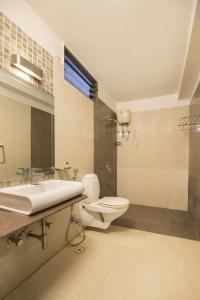 a bathroom with a toilet and a sink at Hotel De Huespedes near international airport in New Delhi