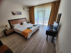 ein Schlafzimmer mit einem Bett und einem Fernseher in einem Zimmer in der Unterkunft Villa Bonita Apartment in Sonnenstrand