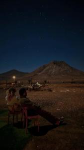 a man and a woman sitting on a chair at night at Caravana Magic in Tindaya